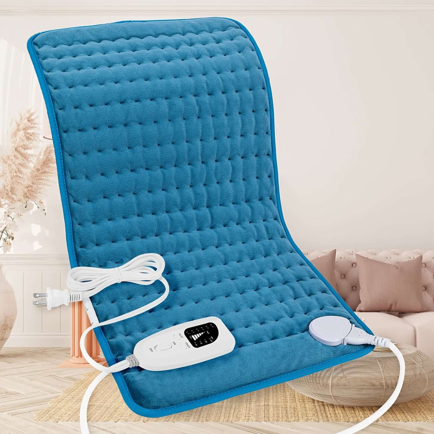 extra large electric heating pad in blue color with controller and power cord on a cozy couch display