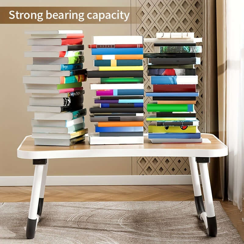 Portable laptop bed table with strong bearing capacity shown with stacked books for demonstration.