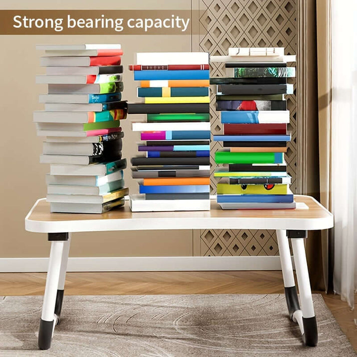 Portable laptop bed table with strong bearing capacity shown with stacked books for demonstration.