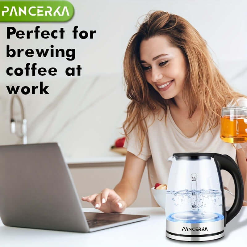 Electric tea kettle with auto shut off on a desk as a woman online at work.