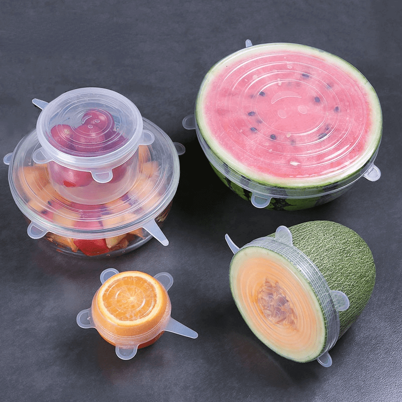 Set of silicone food storage covers on fruits and vegetables for effective food preservation.