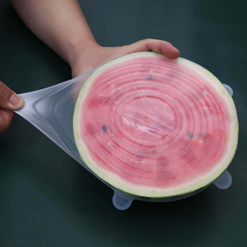 silicone food storage covers used to preserve a cut watermelon, showcasing flexibility and seal.