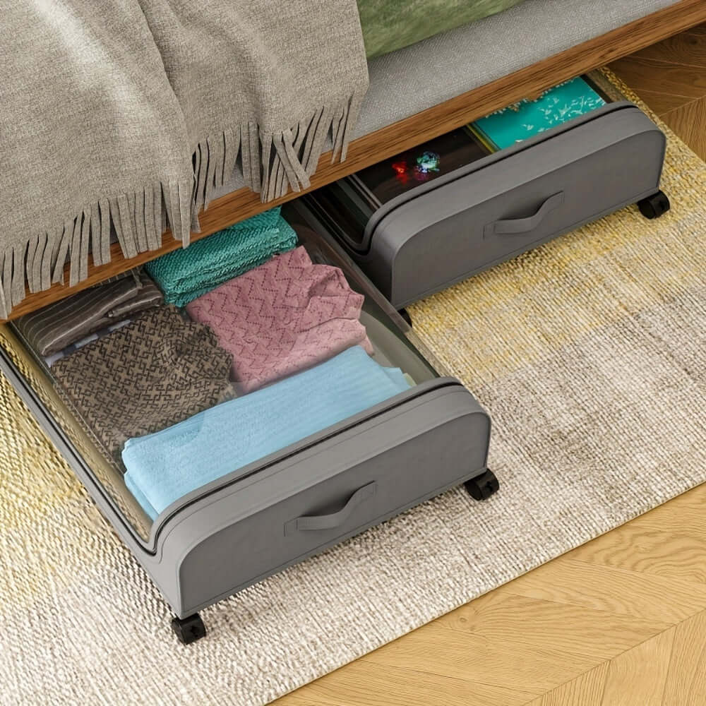Underbed storage bins with wheels displaying organized clothing and blankets under a bed.
