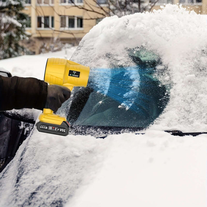 Person using a yellow snowblower to clear snow off a car windshield during winter.