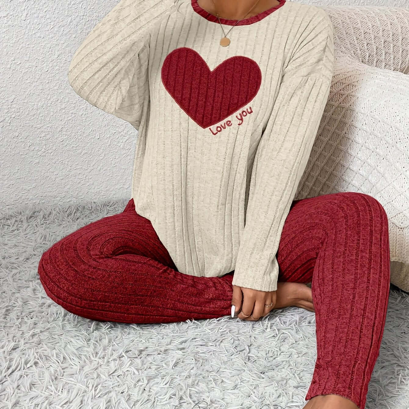 Plus size heart fitted loungewear featuring a cozy sweater with heart design and matching pants in a stylish setting.