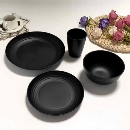 Wheat straw dinnerware set featuring lightweight black plates, bowls, and cups on a decorative table setting.