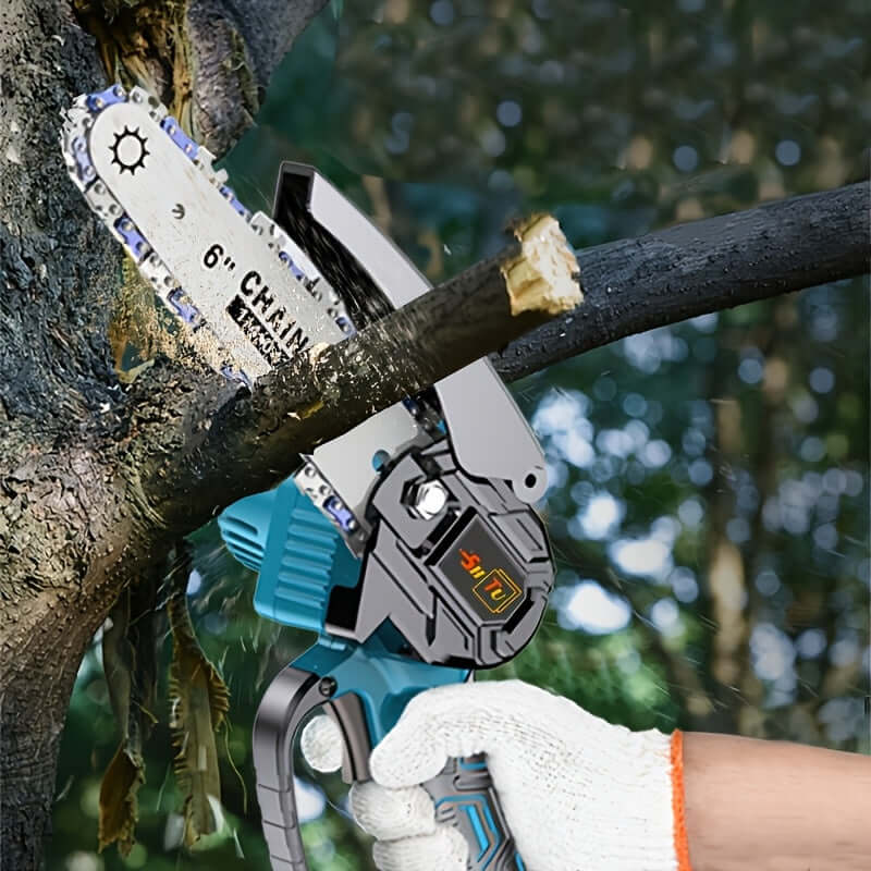 cordless mini chainsaw cutting through a tree branch outdoors with gloved hand holding the tool