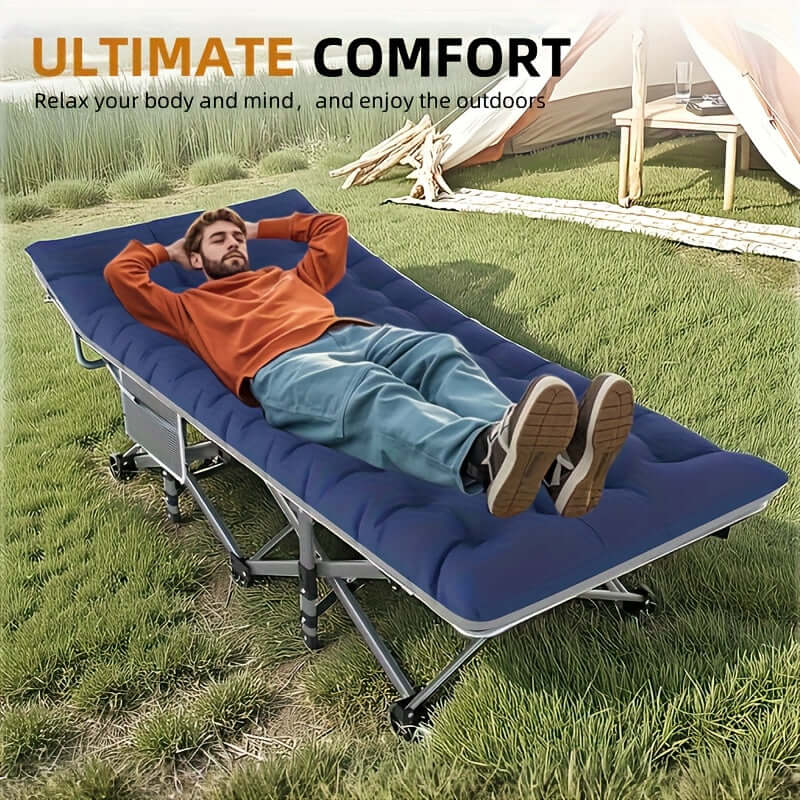 Man relaxing on a portable folding guest bed in a grassy outdoor setting.