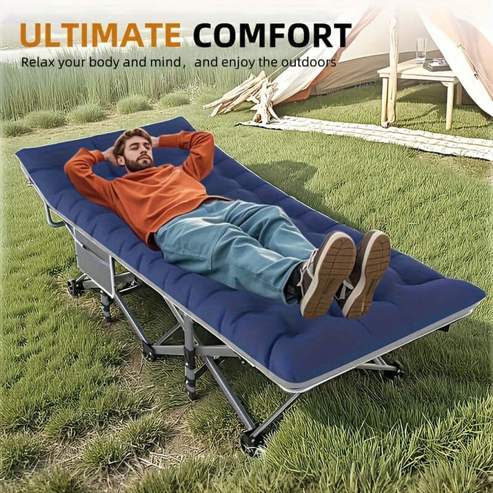 Man relaxing on a portable folding guest bed in a grassy outdoor setting.