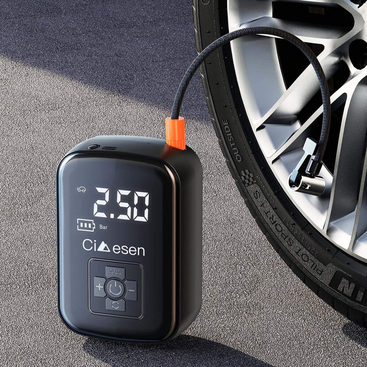 Portable tire inflator with digital display resting on the ground next to a car wheel for easy access.