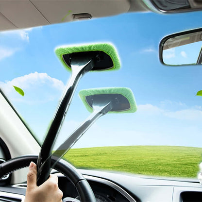 Car window cleaning brush kit in use, effectively cleaning a car windshield with a green cleaning pad.