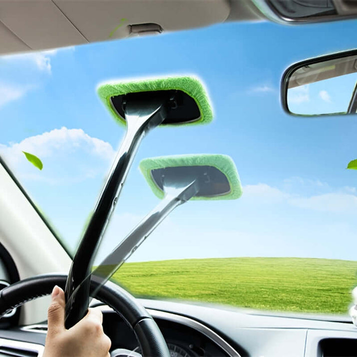 Car window cleaning brush kit in use, effectively cleaning a car windshield with a green cleaning pad.