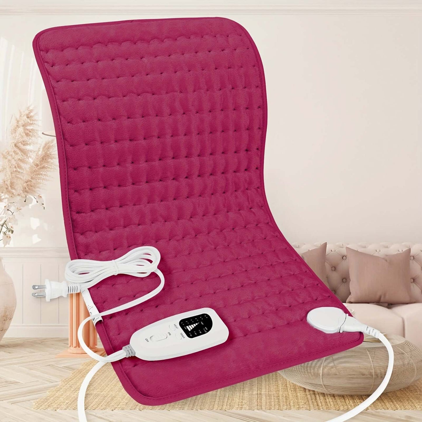 extra large electric heating pad in a cozy living room setting with controls and power cord visible.