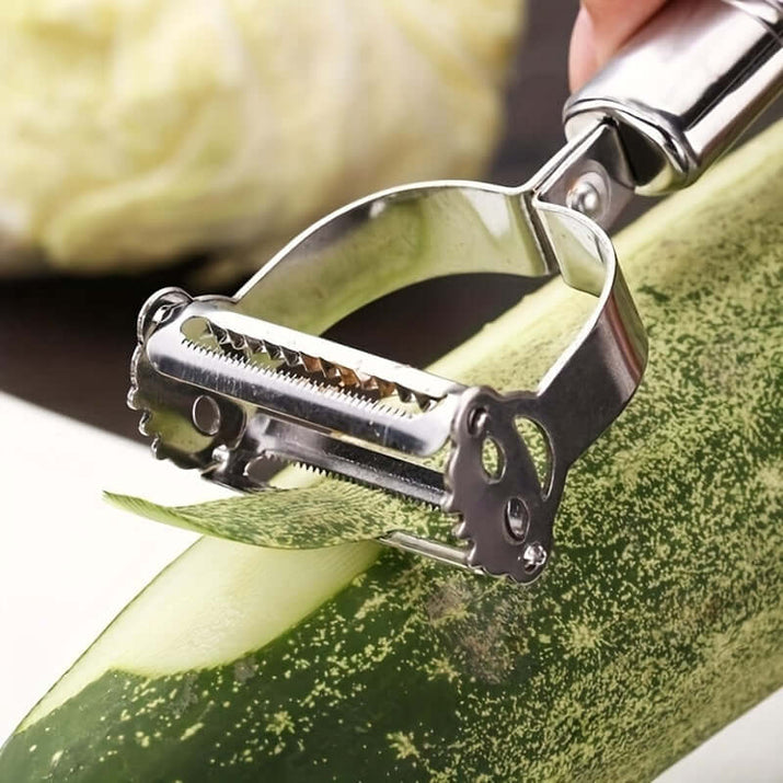 Stainless steel restaurant cookware featuring a professional-grade vegetable peeler in use on a zucchini.