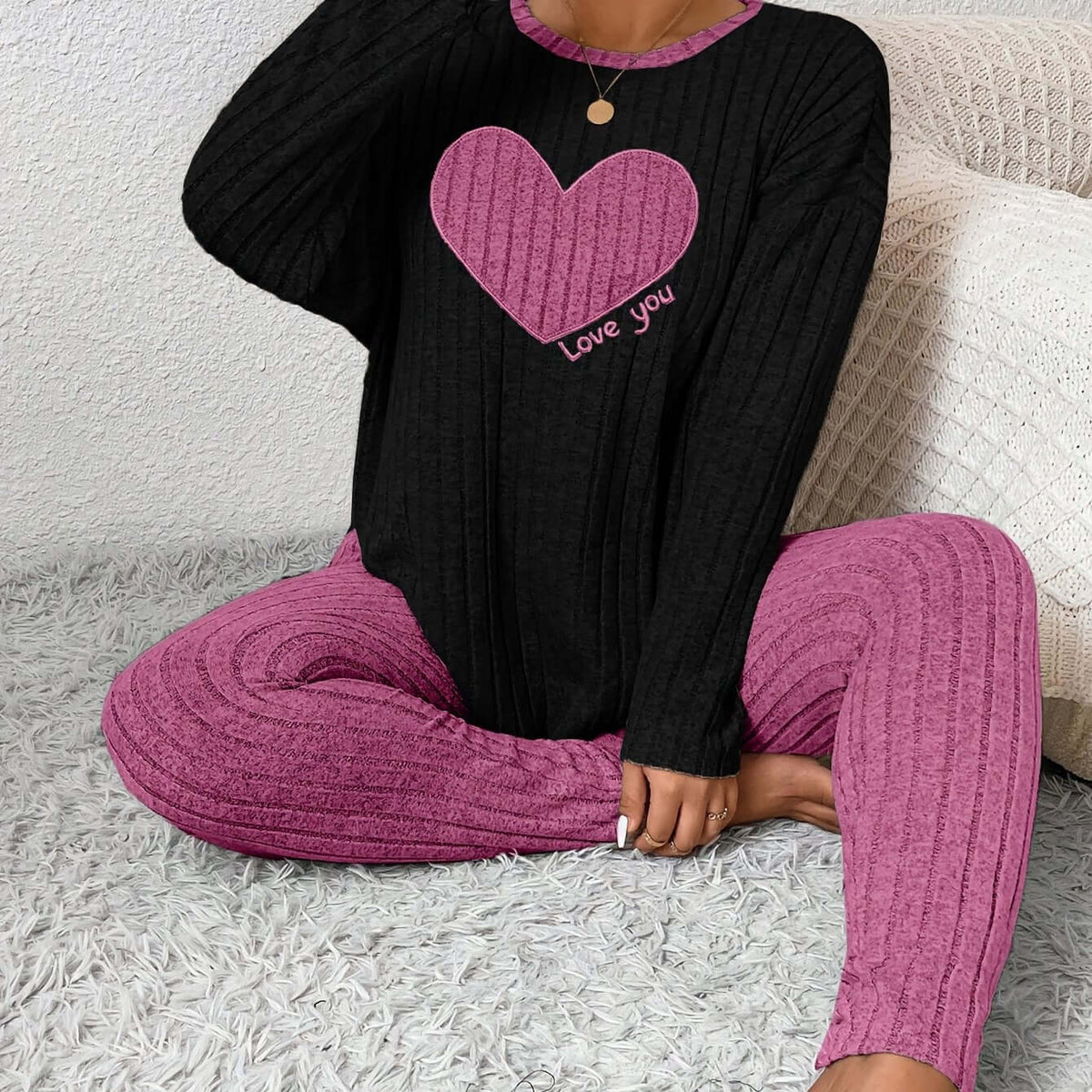 plus size heart fitted loungewear featuring a black top with a pink heart and matching pink pants.