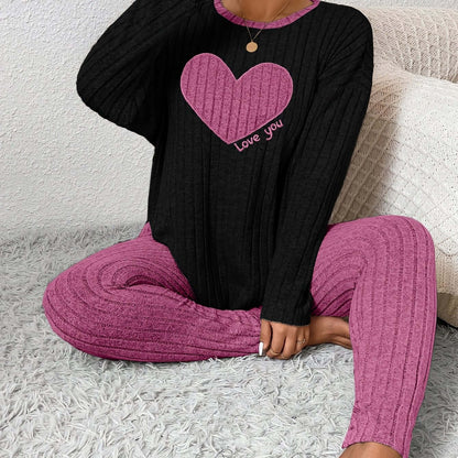 plus size heart fitted loungewear featuring a black top with a pink heart and matching pink pants.