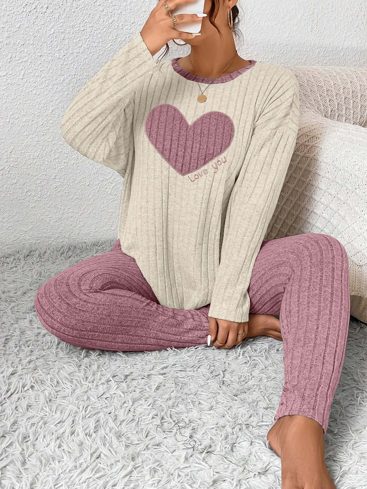 Plus size heart fitted loungewear on a model sitting on a plush rug, featuring a pink heart design.