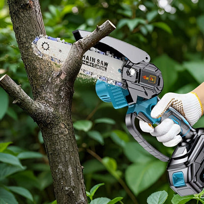 A person using a cordless mini chainsaw to cut a tree branch in an outdoor setting.