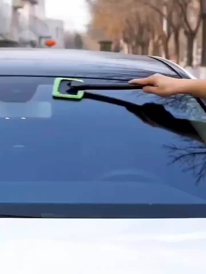 Car window cleaning brush kit in use on a car windshield for effective cleaning.