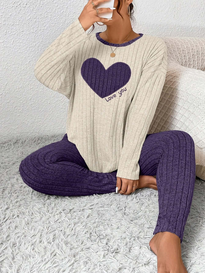 Woman relaxing in plus size heart fitted loungewear with a cozy heart graphic, perfect for casual comfort.
