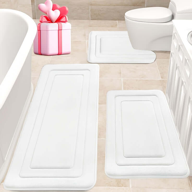 memory foam bath mat set in white color on bathroom floor with a gift box and toilet in view